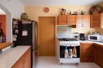 Fully-equipped kitchen with attached laundry room with washer and dryer.